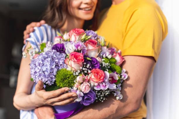 A lady receiving flowers from her husband for their anniversary arranged by a florist in clayton, nc